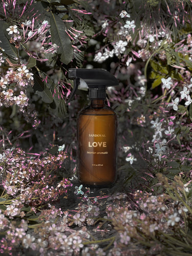 love interior aromatic amber glass bottle printed wit h14 karat gold, in a bouquet of jasmine and flowers