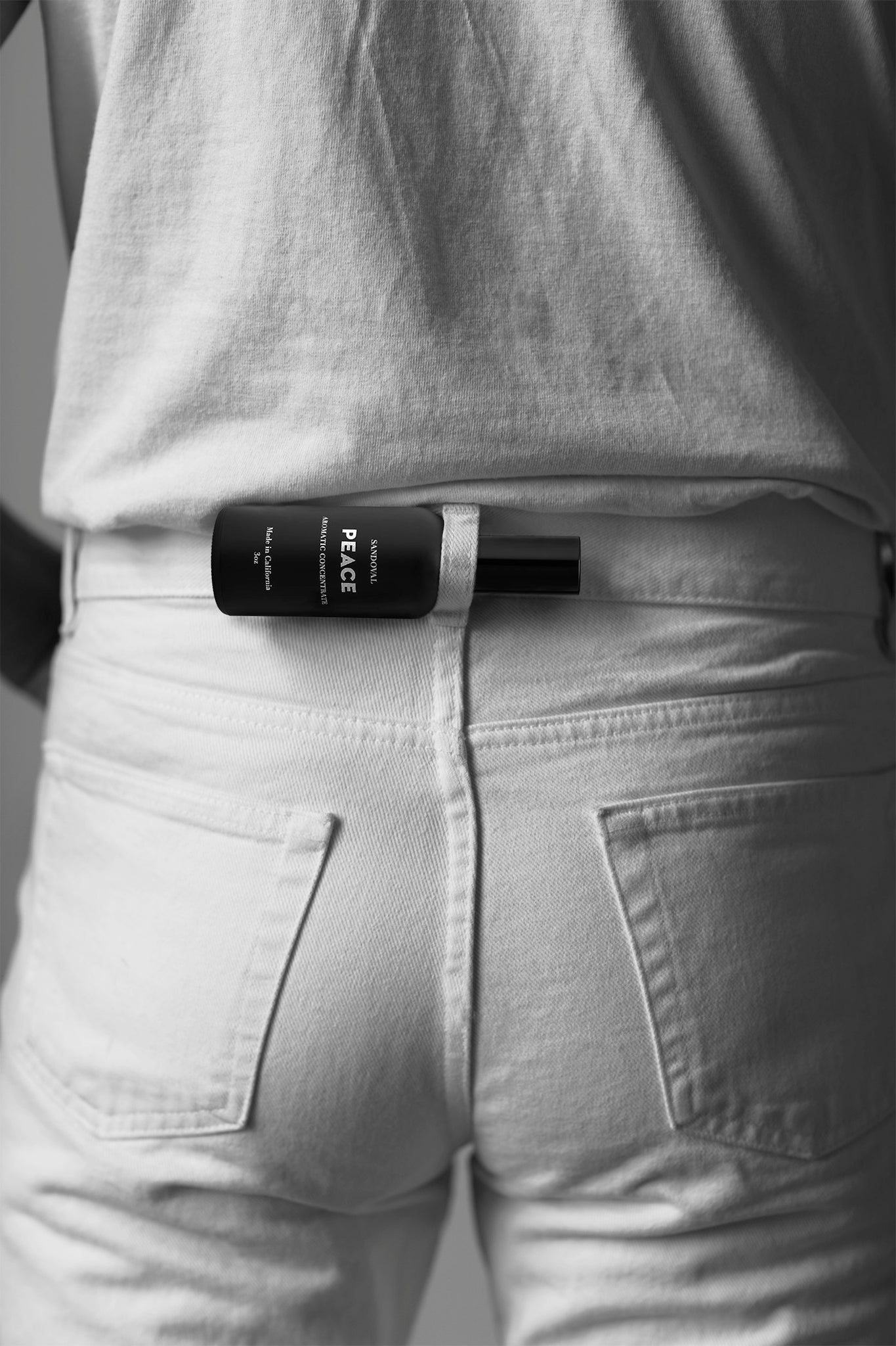 peace aromatic concentrate mist on the go in a belt loop on the back os a pair of white jeans