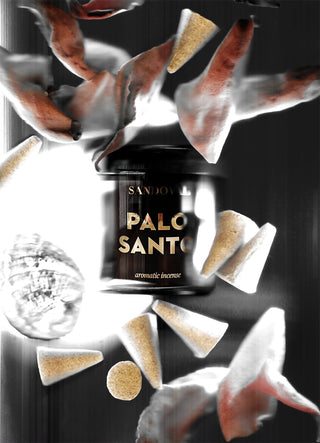 A collage of palo santo aromatic incense cones with dried magnolia petals, an abalone shell and a bright light that represents the full moon light 
